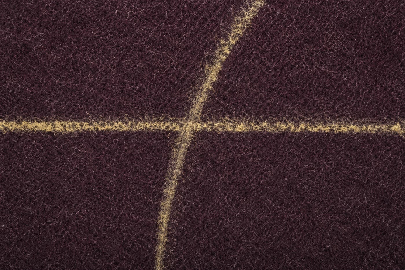 Macro photograph of chalk marking lines drawn on dark wool cloth, one straight and one curved